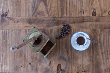 Freshly made coffee with grains and a grinder