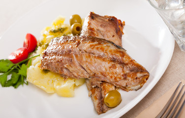 Delicious fried mackerel fillets with mashed potatoes, olives and tomatoes