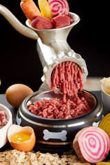 Mincing a selection of raw meat for barf pet food