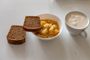 potatoes with meat, Chuvash dairy product and three pieces of Borodino bread on a white table