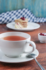 cup of tea piece of cake on the plate vertical composition selective focus