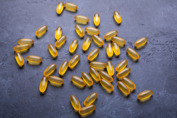 Capsules Omega 3 on dark stone background Close up Health care concept