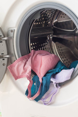 Washing machine full of dirty clothes.