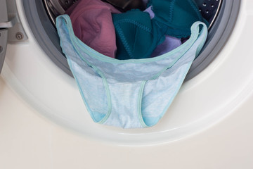 Washing machine full of dirty clothes.