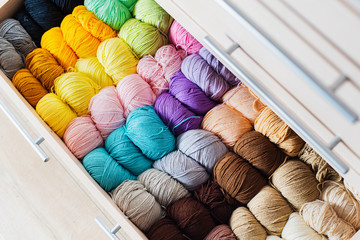 Fototapeta na wymiar Needlework and crocheting and knitting. . Colorful multicolored skeins of yarn in the dresser. Women's hobby.