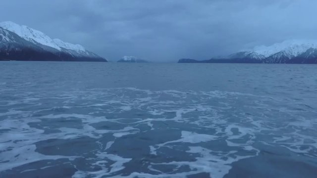 Footage of evening tide in Alaska moving water in bay around with storm weather approaching 