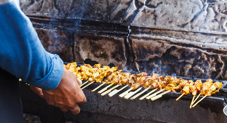 Obraz premium appetizer dish of traditional Thai street food recipe, Pork Satay Grilled marinated pork skewer stick barbecued on charcoal fire grill. Thailand Asia Food Travel, Fast Food, Culinary, Cuisine, Gourmet