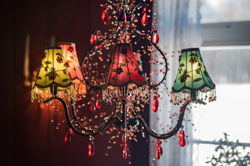 Old vintage chandelier with colorful textile cover on the wall with copyspace