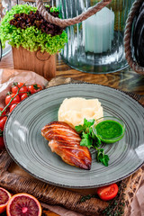 Fried chicken fillet, mashed potatoes and sauce in a gray plate on a wooden board in a rustic composition. national Ukrainian and Russian dish. close up. flat lay 