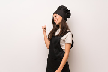 Teenager chef  over white wall pointing back