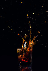 Isolated shot of whiskey with splash on black background