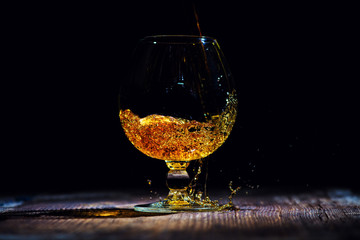 glass with cognac on a wooden background