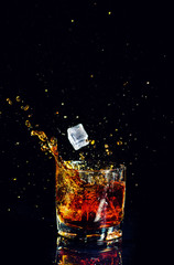 Isolated shot of whiskey with splash on black background