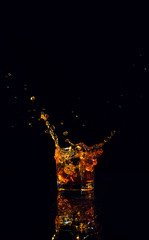 Isolated shot of whiskey with splash on black background