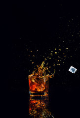 Isolated shot of whiskey with splash on black background