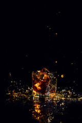 Isolated shot of whiskey with splash on black background