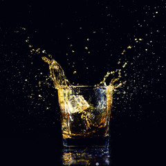 Isolated shot of whiskey with splash on black background