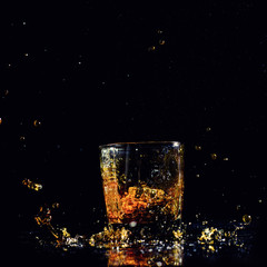Isolated shot of whiskey with splash on black background