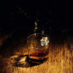 Isolated shot of whiskey with splash on black background