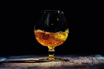 glass with cognac on a wooden background
