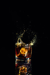Isolated shot of whiskey with splash on black background