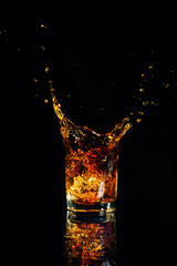 Isolated shot of whiskey with splash on black background