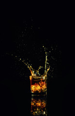 Isolated shot of whiskey with splash on black background