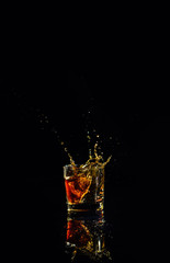 Isolated shot of whiskey with splash on black background