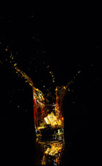 Isolated shot of whiskey with splash on black background