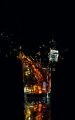 Isolated shot of whiskey with splash on black background