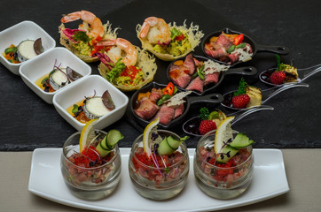 Buffet table with appetizers in a restaurant with krudite, guacamel, ceviche, bluefin, caviar, prawns and goat cheese