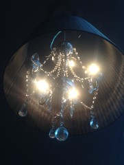 Black chandelier on black ceiling with foggy light