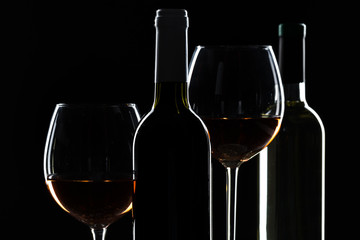  wine bottle and wine glass in a black background