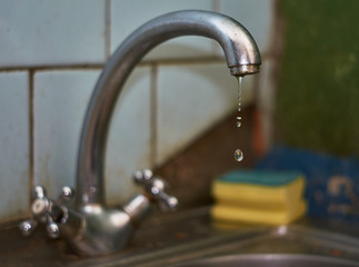 Old dripping kitchen faucet close up.