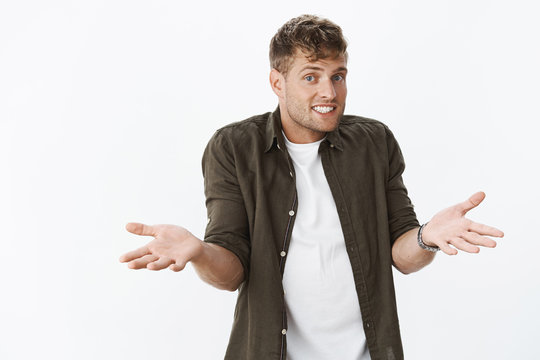 Have no idea. Unaware charismatic and cute fair-haired masculine male with bristle making shoulder shrugg with hands sideways and sorry smile as being uncertain and clueless, confused with question