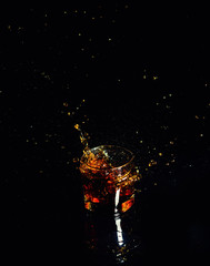 Isolated shot of whiskey with splash on black background