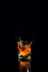 Isolated shot of whiskey with splash on black background