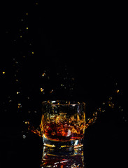 Isolated shot of whiskey with splash on black background