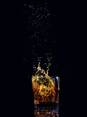 Isolated shot of whiskey with splash on black background