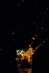 Isolated shot of whiskey with splash on black background