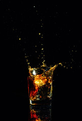 Fototapeta na wymiar Isolated shot of whiskey with splash on black background