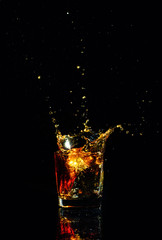 Isolated shot of whiskey with splash on black background