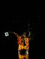 Isolated shot of whiskey with splash on black background