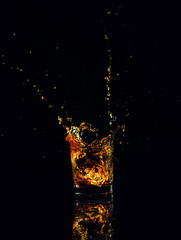 Isolated shot of whiskey with splash on black background