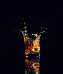 Isolated shot of whiskey with splash on black background
