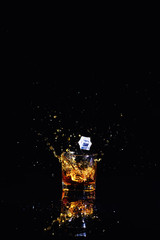 Isolated shot of whiskey with splash on black background