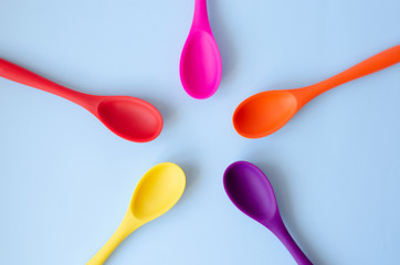 Fletley from multi-colored spoons on a blue background.