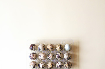 Plastic packaging with quail eggs on a yellow background.