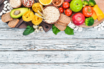Concept of healthy food: bread, pasta, avocado, flour, pumpkin, broccoli, beans, spinach. Vegetables and fruits. Top view. Free copy space.
