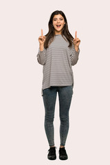 A full-length shot of a Teenager girl with striped shirt pointing with the index finger a great idea over isolated background